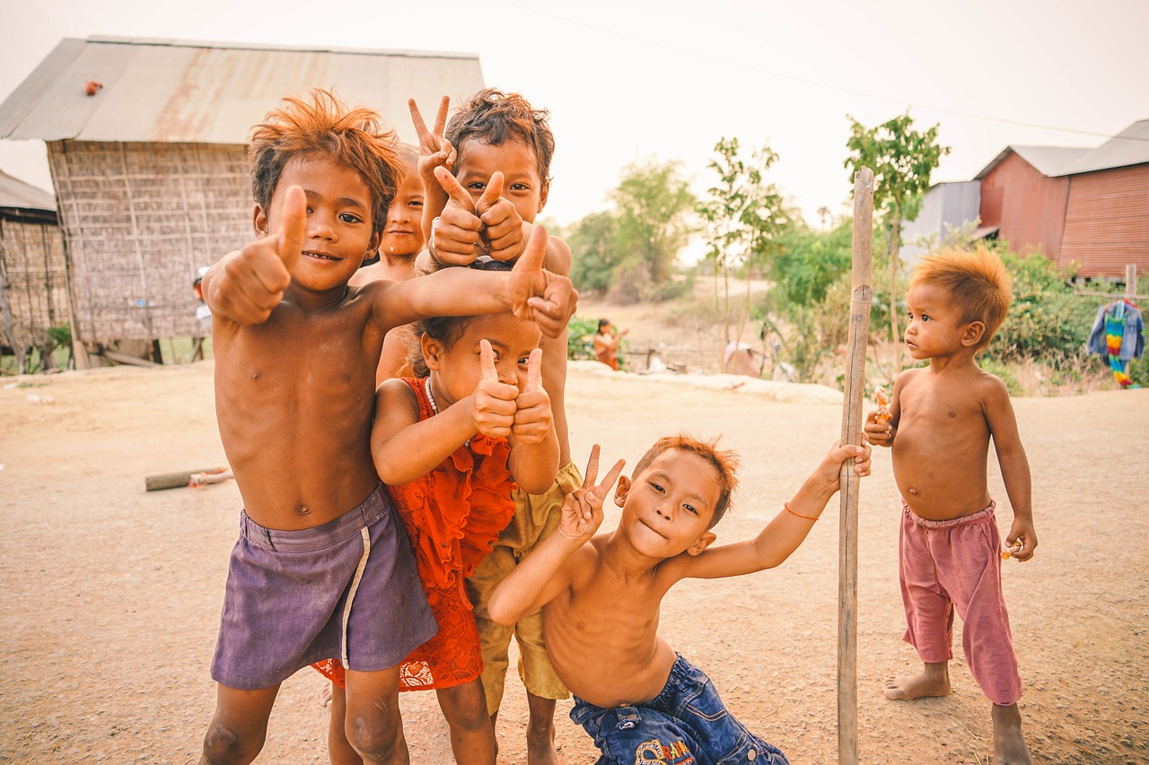 Six young Asian children giving peace signs
